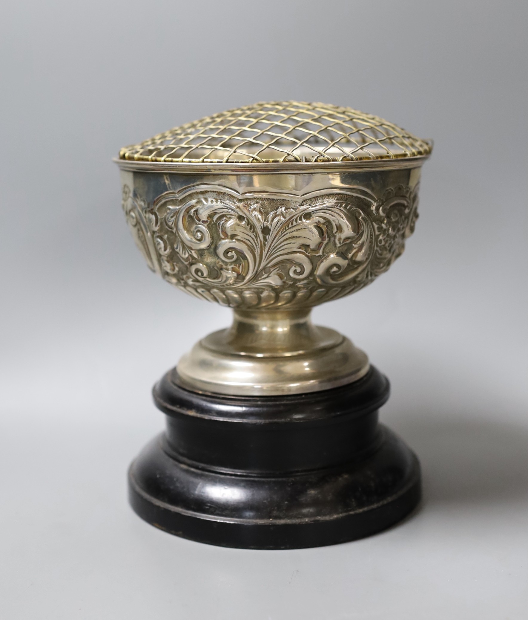 An Edwardian repousse silver rose bowl, with later engraved inscription, diameter 16.6cm, 9.5oz, on ebonised socle.